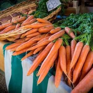 Vibrant fresh carrots on sale at a local farmers market, showcasing organic produce.